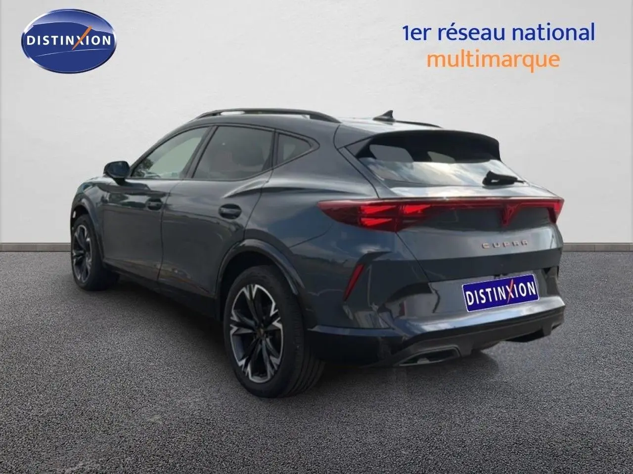Vue 3/4 arrière droite du CUPRA Formentor gris magnétique métal avec feux arrière allongés et jantes noires distinctives.