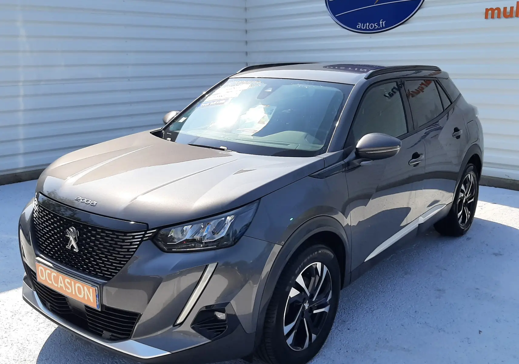 Peugeot 2008 gris Artense vue 3/4 avant droit, SUV compact avec calandre noire et jantes alliage noires.