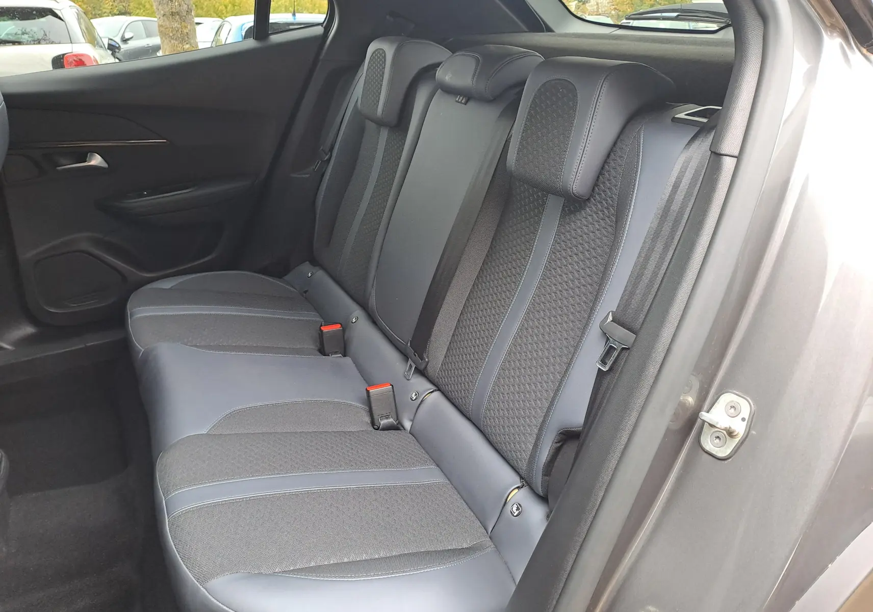 Vue côté droit de la banquette arrière gris anthracite et tissu du Peugeot 2008 gris Artense 2020 avec ceintures de sécurité visibles.