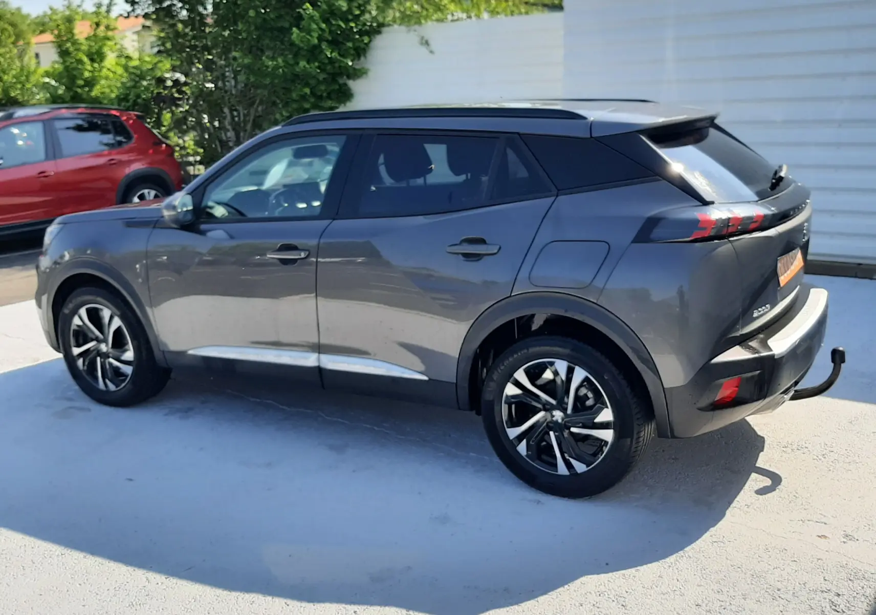 Peugeot 2008 gris Artense vue de profil côté gauche, avec toit noir et jantes alliage distinctives.