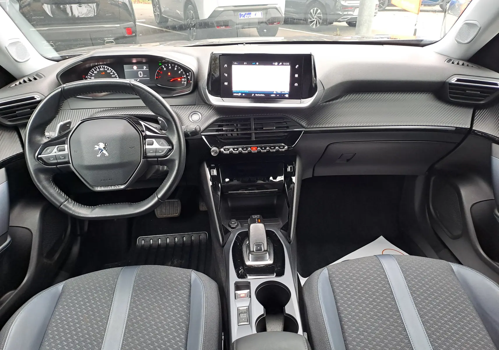Intérieur noir du Peugeot 2008 2020, vue frontale sur le tableau de bord avec écran tactile et volant compact.