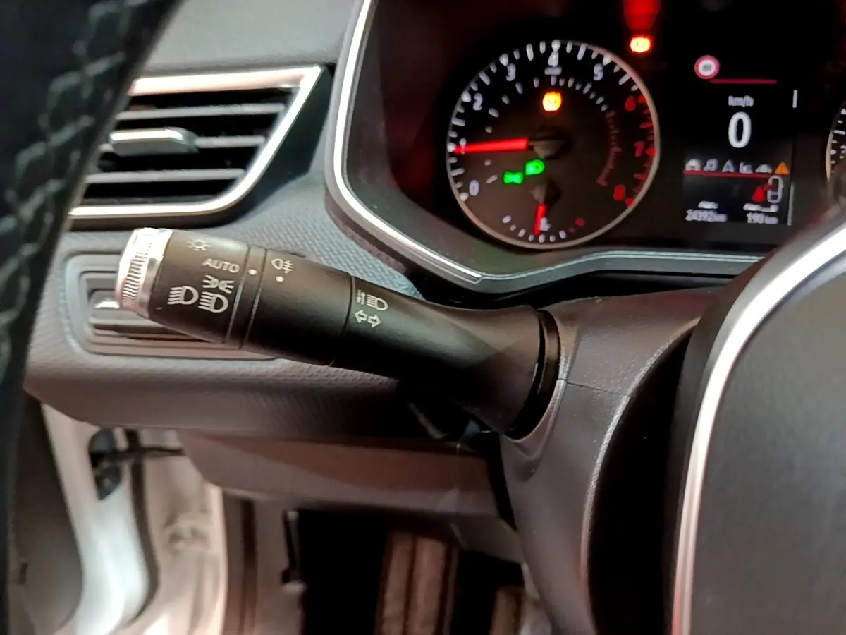 Gros plan sur la commande des phares et clignotants à gauche du volant dans une Renault Clio Business blanche de 2020.