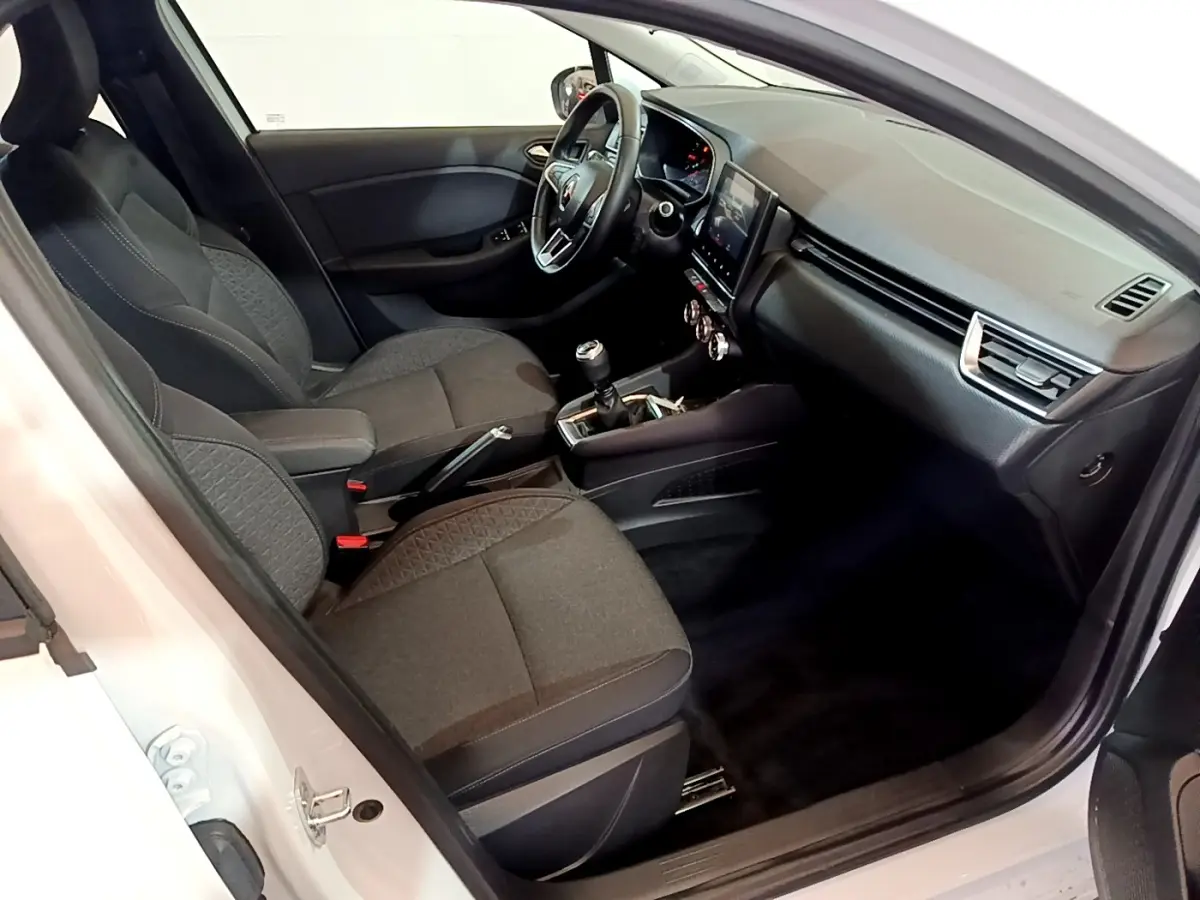 Vue intérieure côté conducteur de la Renault Clio Business TCe 100 2020 blanche, sièges noirs et tableau de bord avec écran tactile.