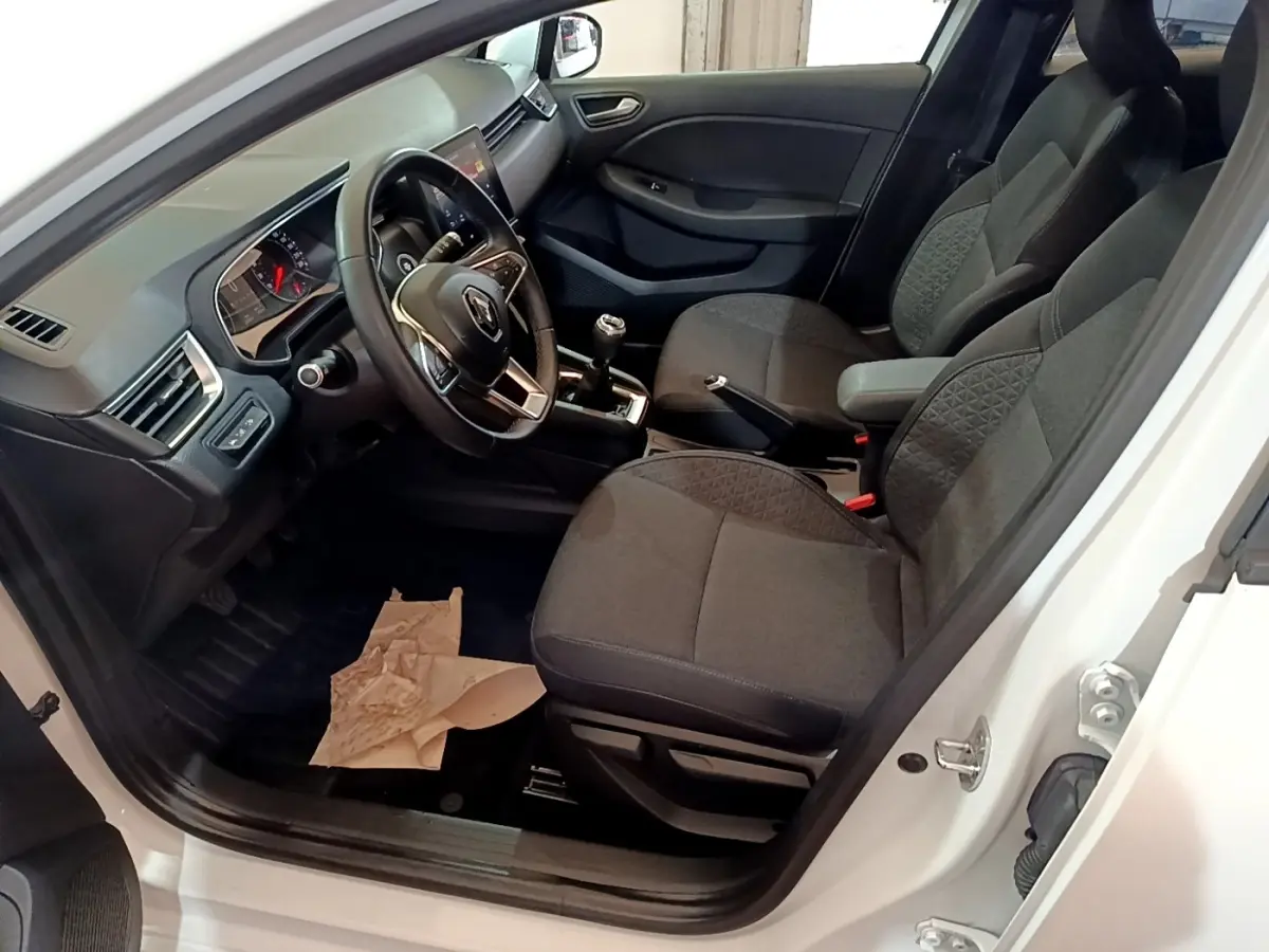 Vue intérieure côté conducteur de la Renault Clio Business TCe 100 2020 blanche, avec volant cuir multifonctions et sièges tissu gris.