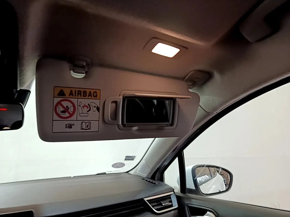 Intérieur de Renault Clio Business blanc 2020, vue côté droit sur pare-soleil avec miroir et avertissement airbag.