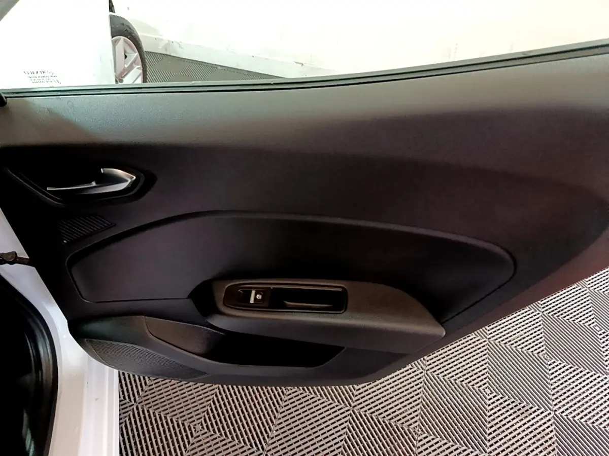 Vue intérieure côté gauche de la porte avant blanche d'une Renault Clio Business TCe 100 avec commande de vitre électrique.