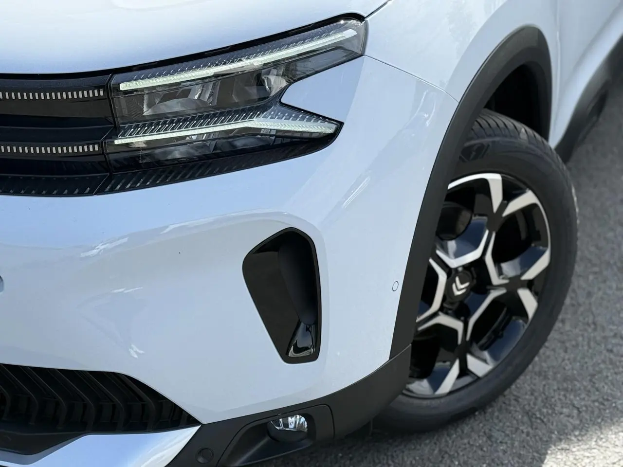 Gros plan 3/4 avant droit du Citroën C5 Aircross blanc Okenite, avec phare LED et jante alliage bi-ton noire et argent.