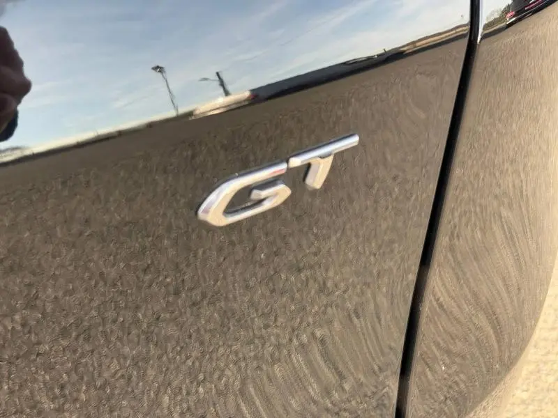 Gros plan sur l’inscription GT sur la porte côté droit d’un Peugeot 3008 Bleu Célèbes avec toit noir.
