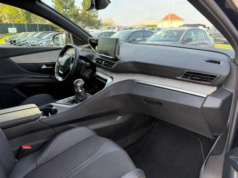 Vue intérieure côté conducteur du Peugeot 3008 2024, mettant en valeur le tableau de bord moderne et la boîte manuelle.