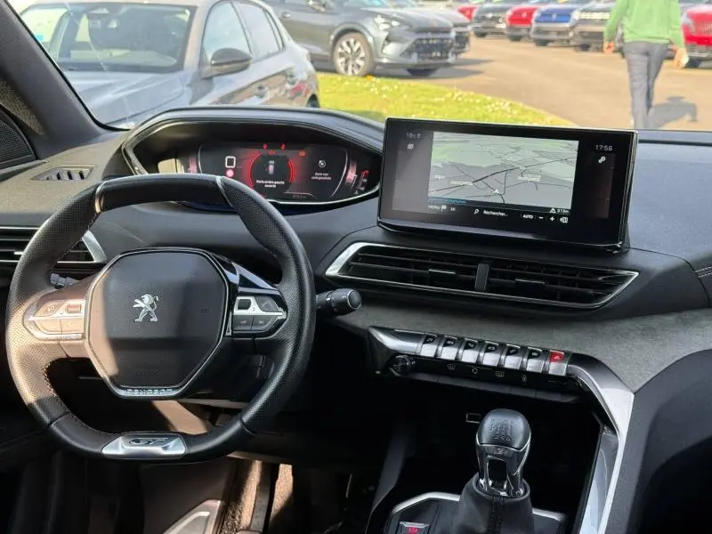 Vue intérieure du poste de conduite du Peugeot 3008 2024, avec volant compact, écran tactile central et levier de vitesses manuel.
