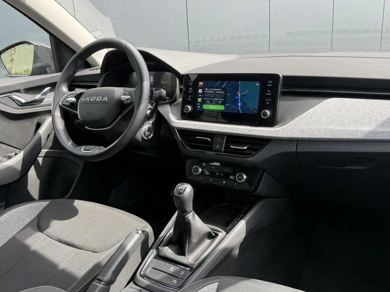 Intérieur de la Skoda Scala TSI 116 gris graphite, vue côté conducteur avec tableau de bord et écran tactile central.