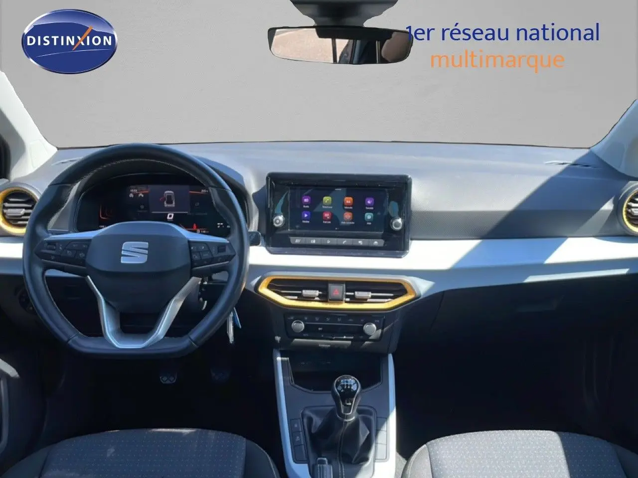 Vue intérieure frontale du tableau de bord de la SEAT Arona gris magnetic avec volant cuir et écran tactile central.