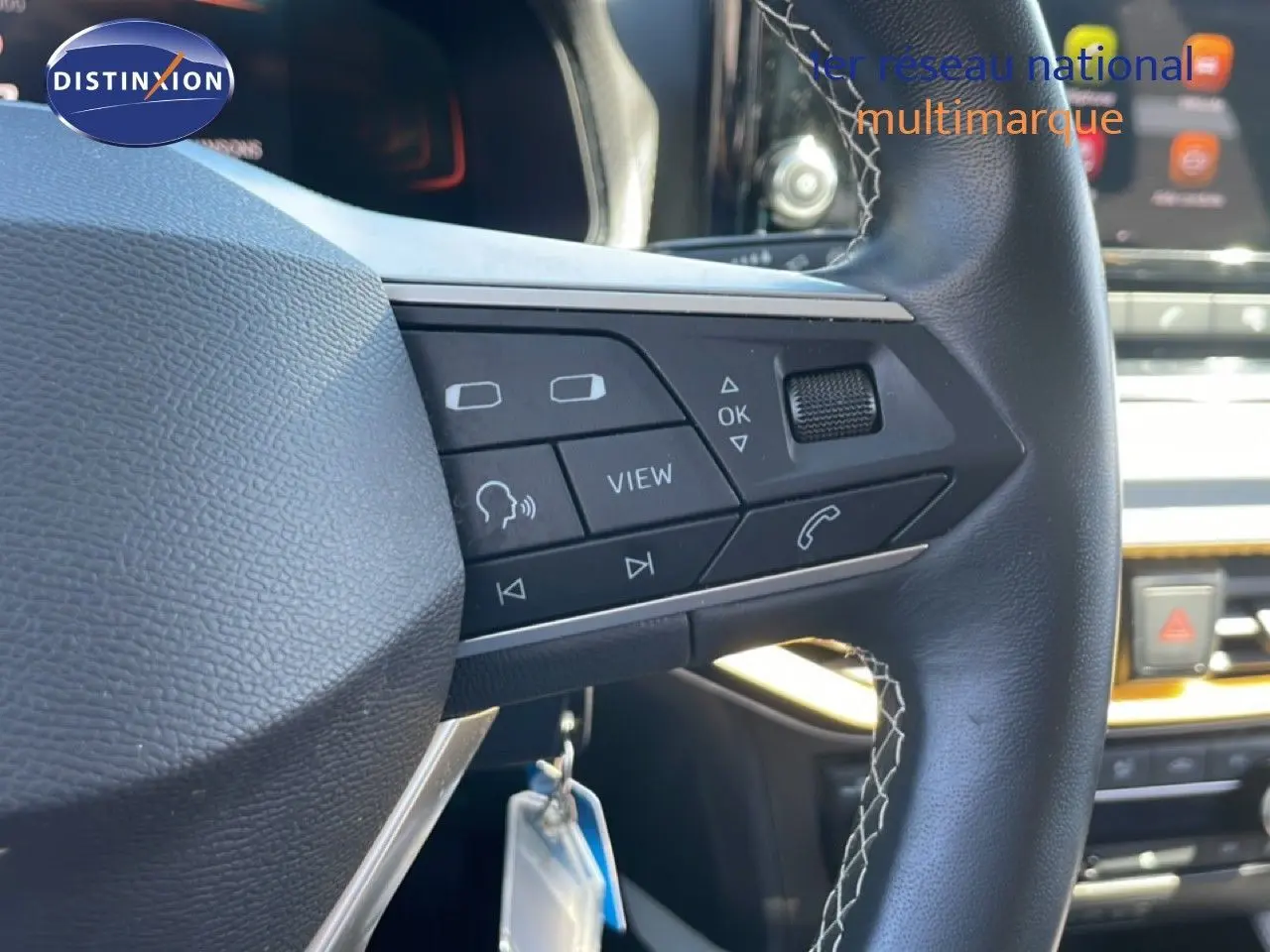 Gros plan sur le volant cuir noir avec commandes multifonctions du SEAT Arona gris Magnetic Metal, intérieur moderne.
