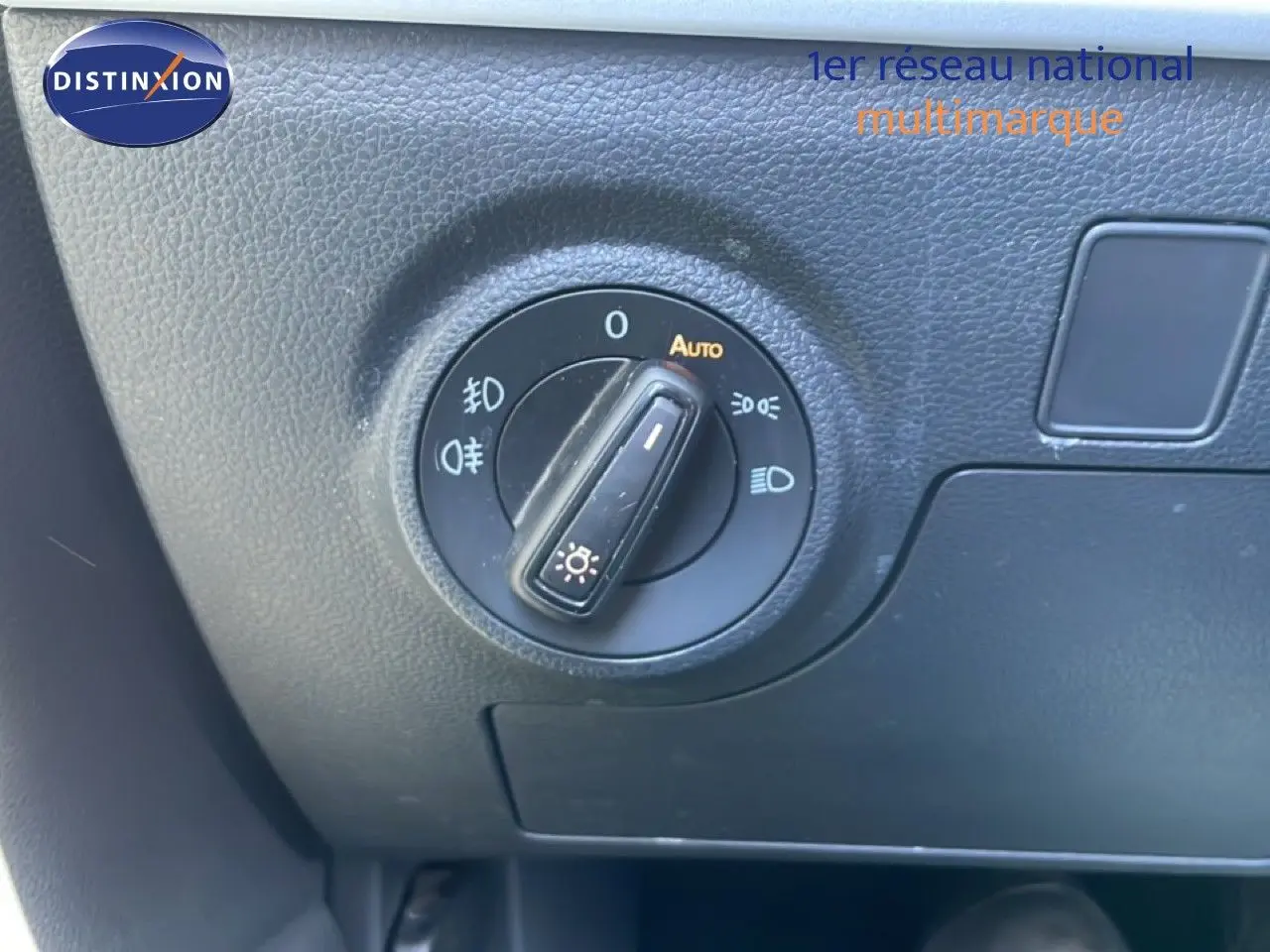 Gros plan sur le sélecteur de phares du tableau de bord d’un SEAT Arona 2025 gris magnetic metal avec toit noir.