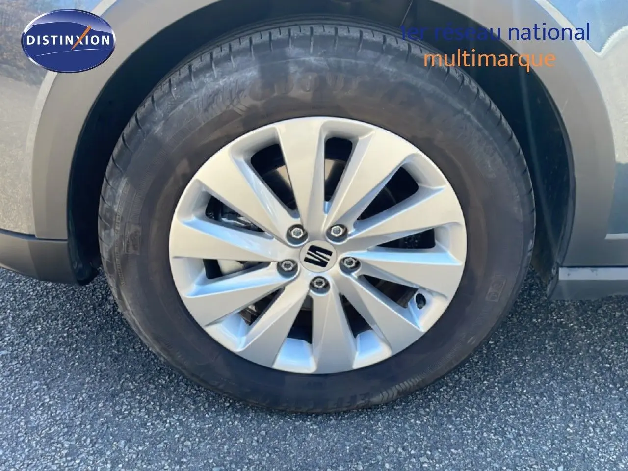 Gros plan sur la roue avant droite d'une SEAT Arona gris magnetic metal avec jante alliage 16 pouces.