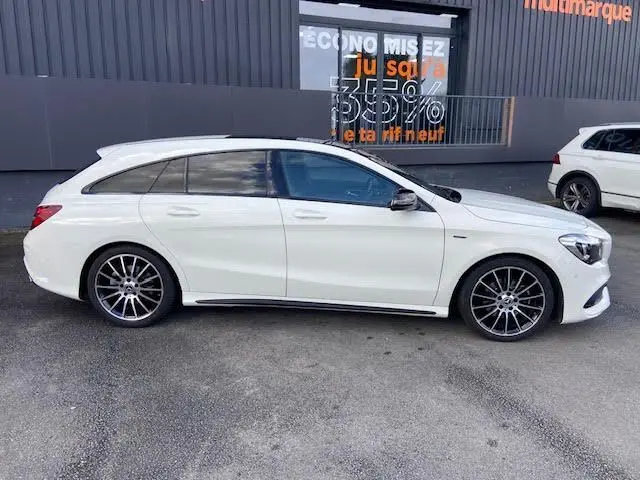 Profil côté droit d'une Mercedes CLA Shooting Brake 200D WhiteArt blanche avec jantes AMG noires bicolores.
