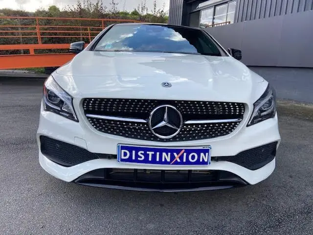 Vue frontale d'une Mercedes CLA Shooting Brake 200D WhiteArt Edition blanche avec calandre diamantée et logo étoile central.
