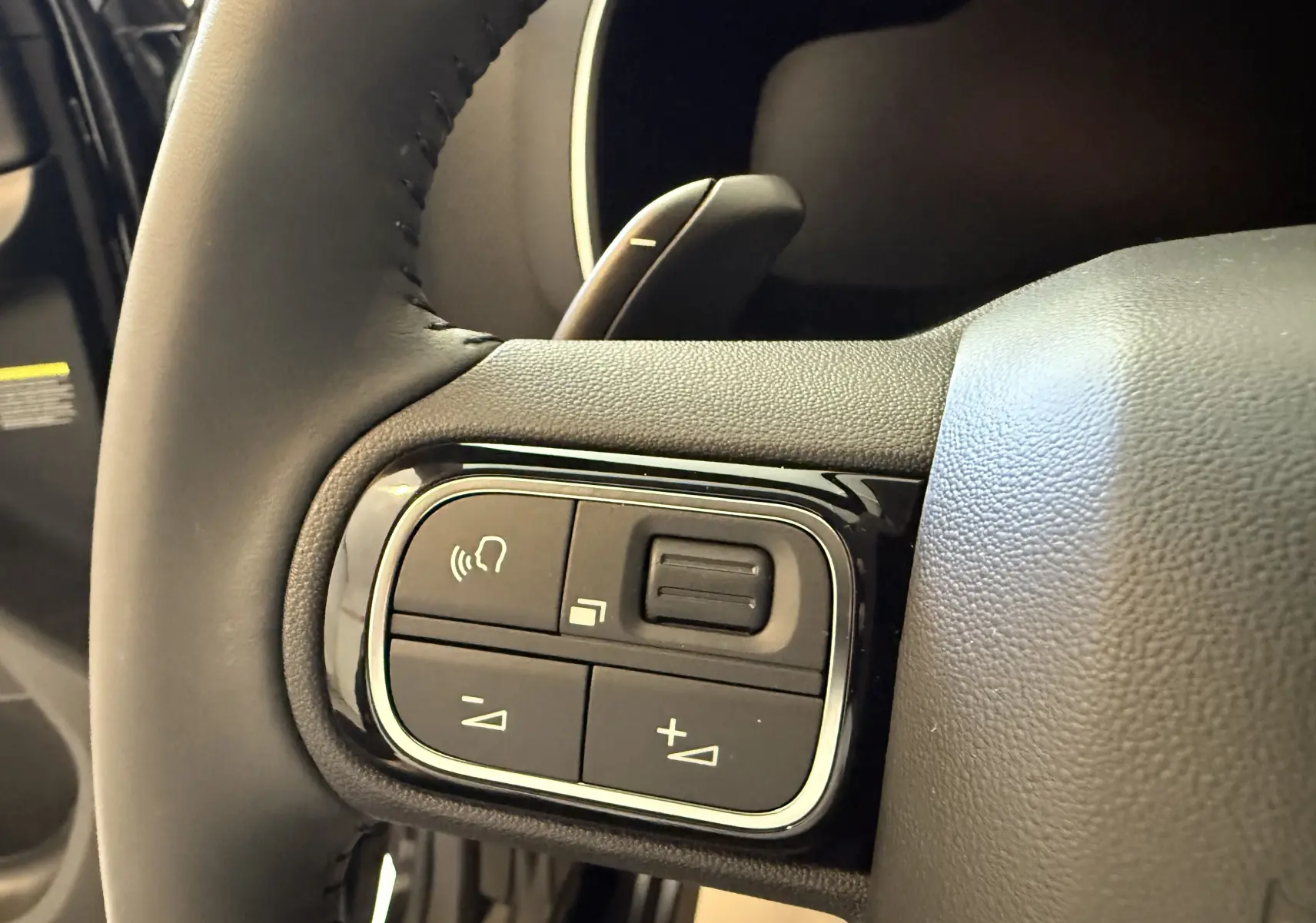 Gros plan sur les commandes du volant en cuir noir du Citroën C5 Aircross gris Artense 2022, version Shine.