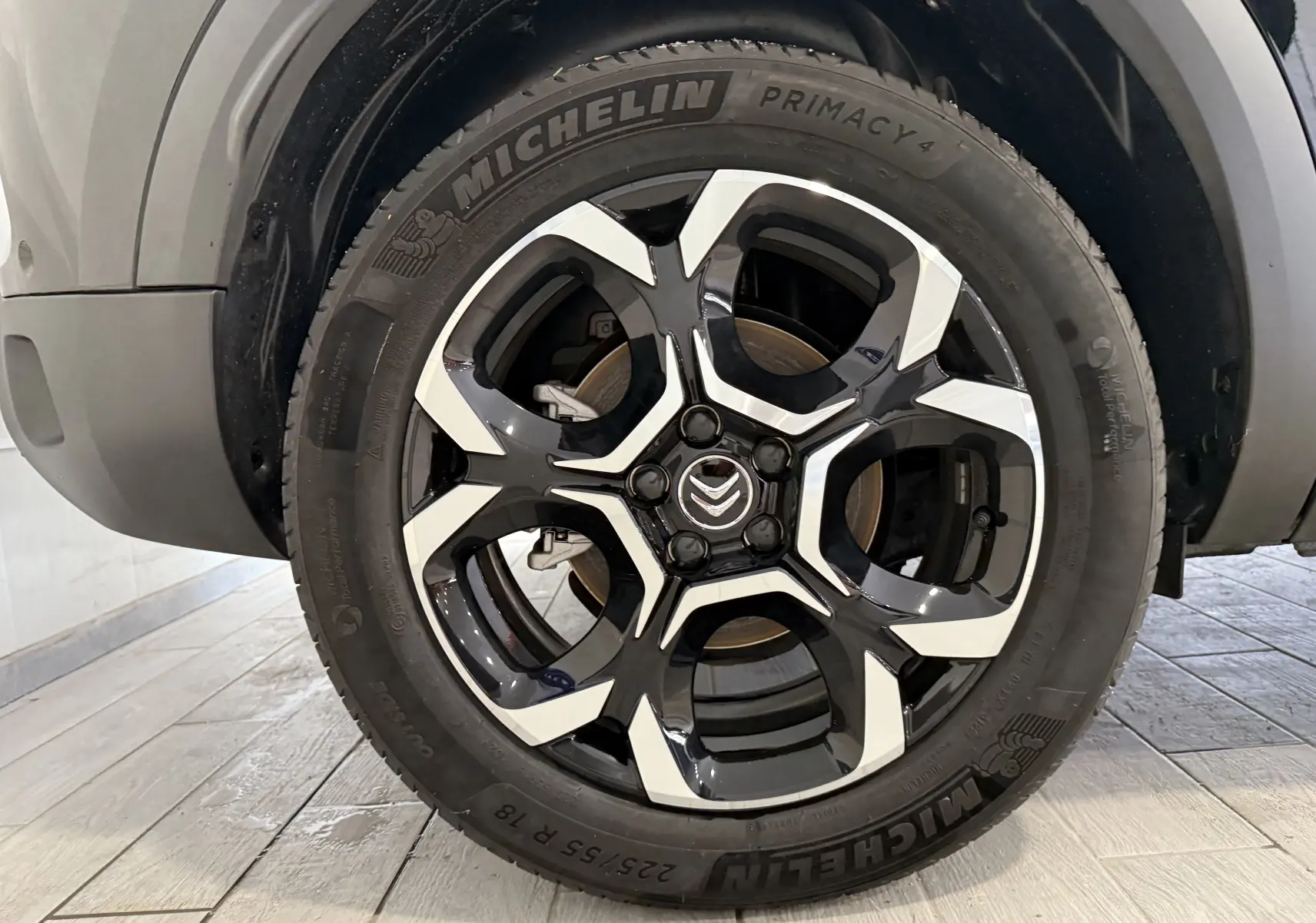 Gros plan sur la roue avant gauche du Citroën C5 Aircross gris Artense, jante alliage noire et argentée distinctive.