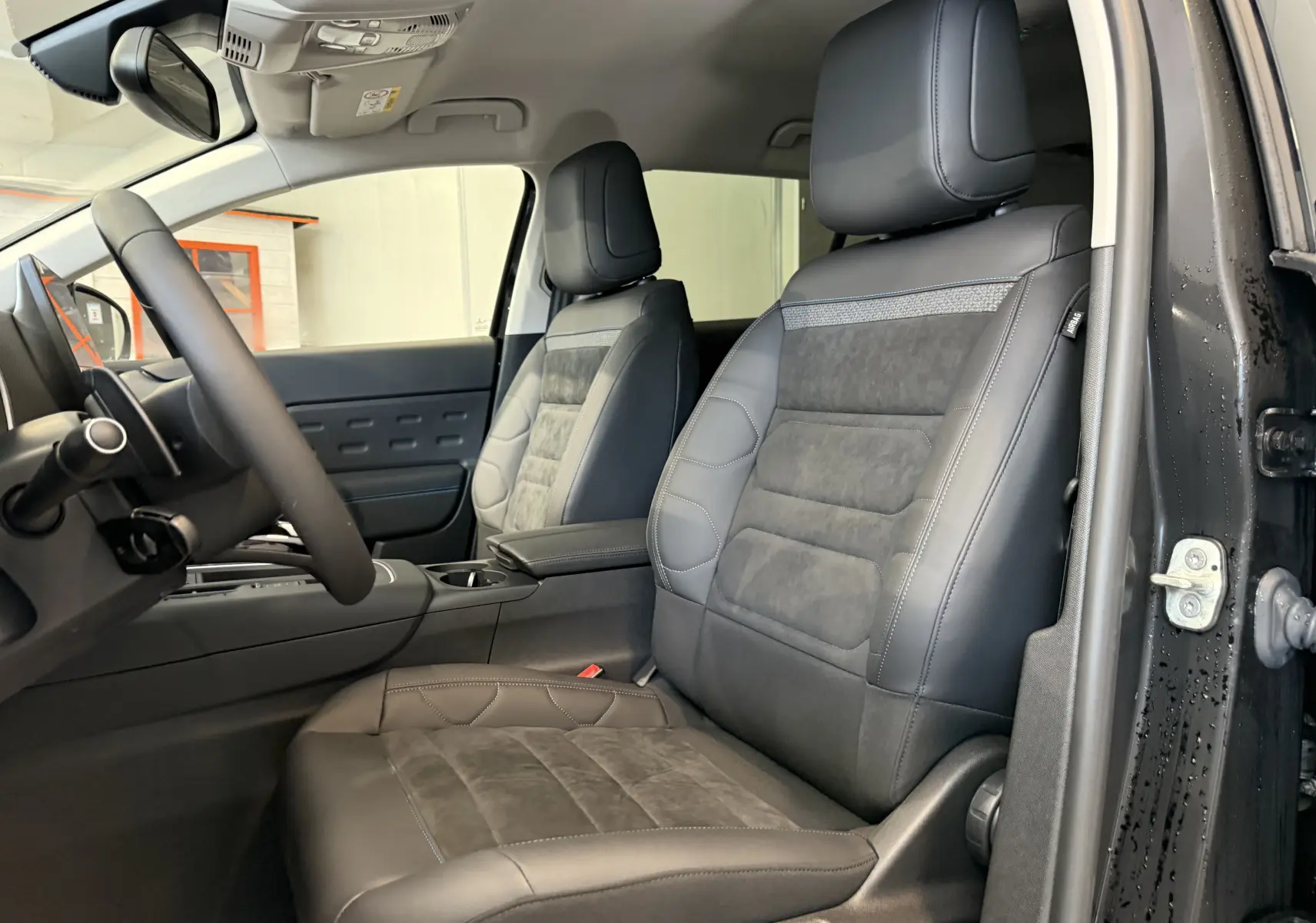 Vue intérieure côté conducteur du Citroën C5 Aircross 2022, sièges en cuir noir avec inserts tissu gris.