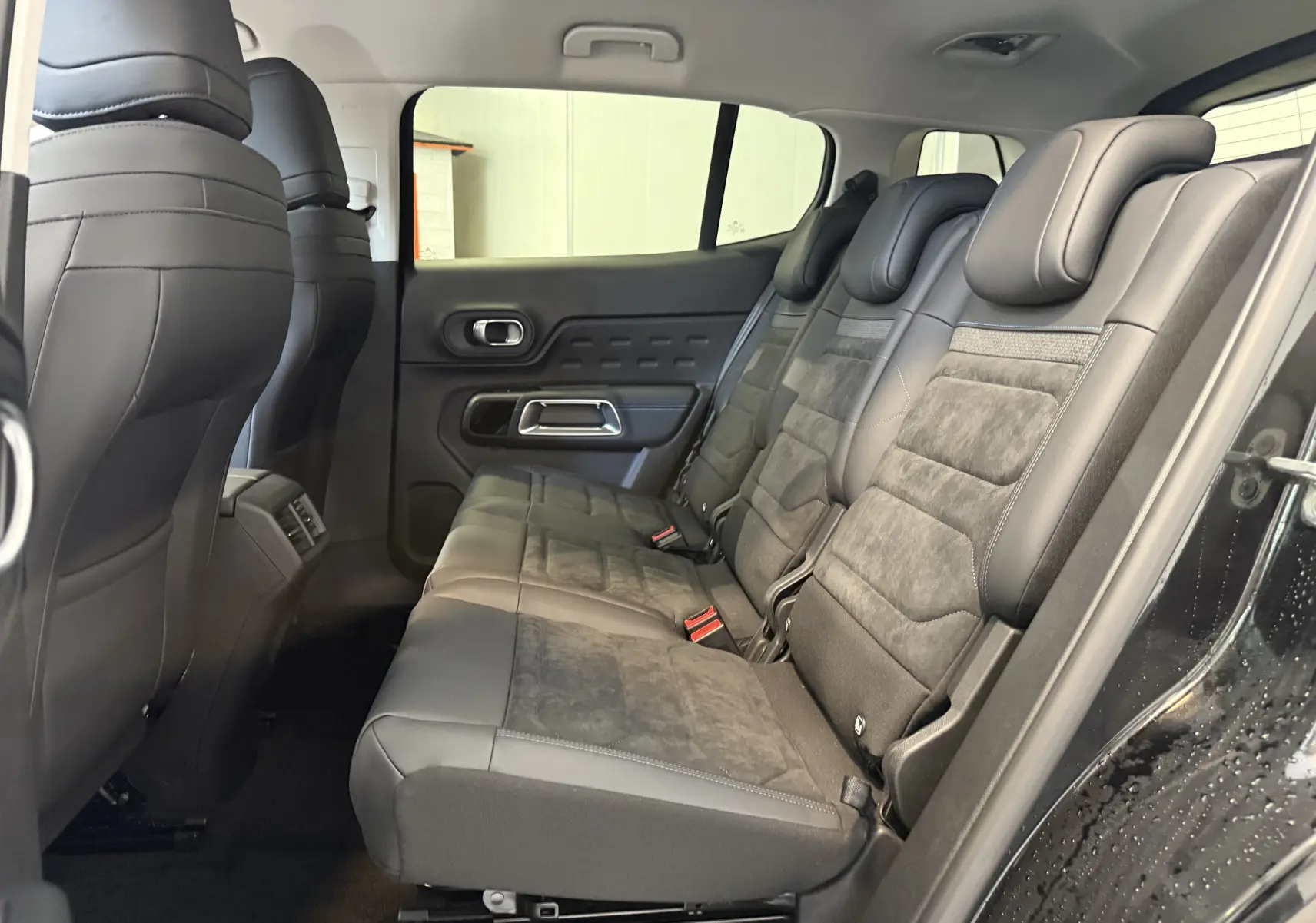 Vue latérale droite de l'intérieur arrière du Citroën C5 Aircross 2022, sièges en cuir noir et tissu gris.