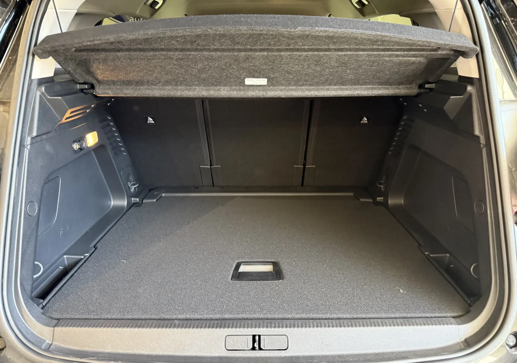 Coffre ouvert du Citroën C5 Aircross gris Artense, montrant un espace de chargement propre et bien agencé.