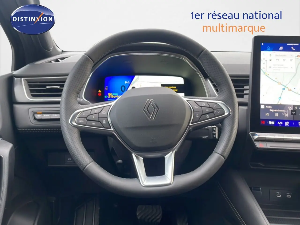 Vue centrée sur le volant noir perforé de la Renault Symbioz 2025 avec tableau de bord numérique et écran tactile.