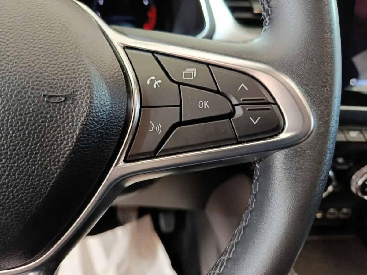 Gros plan sur les commandes multifonctions du volant noir du Renault Captur Techno TCe 90 2024.