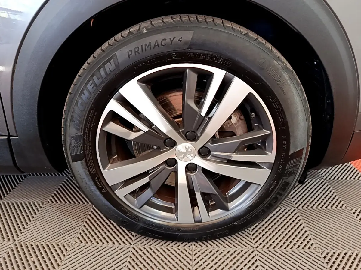 Gros plan sur la roue avant droite du Peugeot 3008 gris foncé avec jante alliage et pneu Michelin Primacy 4.