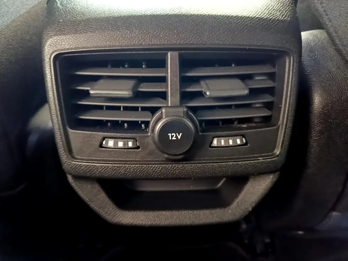 Gros plan sur la sortie d’air arrière noire avec prise 12V du Peugeot 3008 hybride gris foncé, version 2022.
