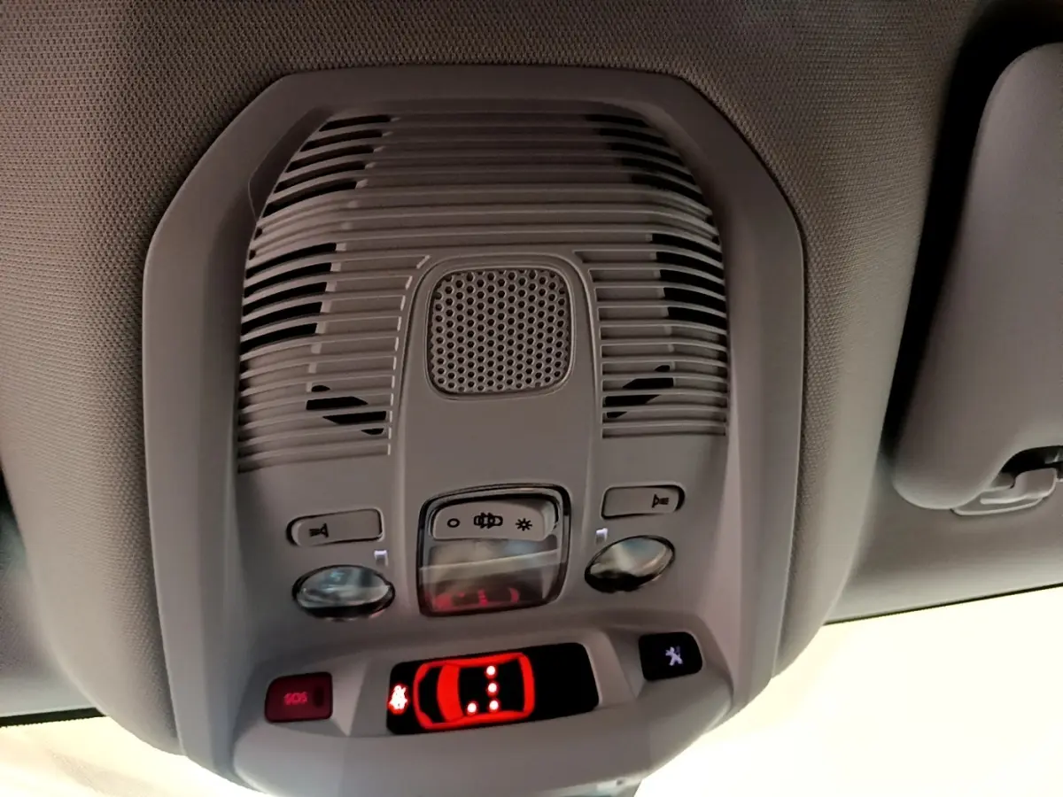 Vue en gros plan du plafonnier gris du Peugeot 3008 hybride 2022 avec boutons de commande et affichage lumineux rouge.