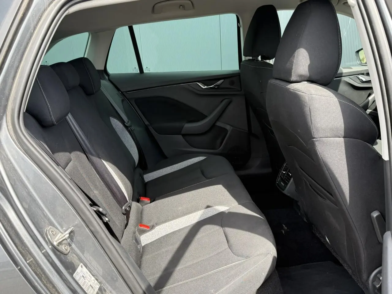 Vue intérieure côté gauche des sièges arrière noirs et gris d'une Skoda Scala TSI 116 Sélection 2025 en gris graphite.