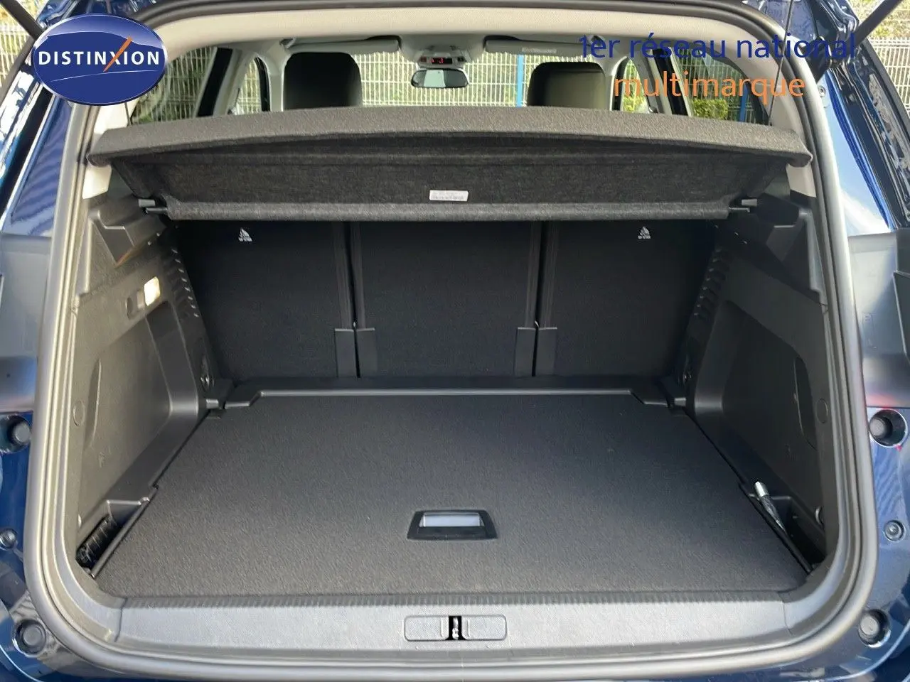 Coffre ouvert vu de l'arrière d'un Citroën C5 Aircross bleu Eclipse métal, montrant un espace de chargement spacieux.