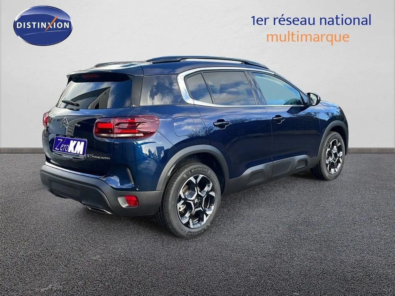 Vue 3/4 arrière droite d'un Citroën C5 Aircross bleu Eclipse Metal avec jantes alliage et protections noires.