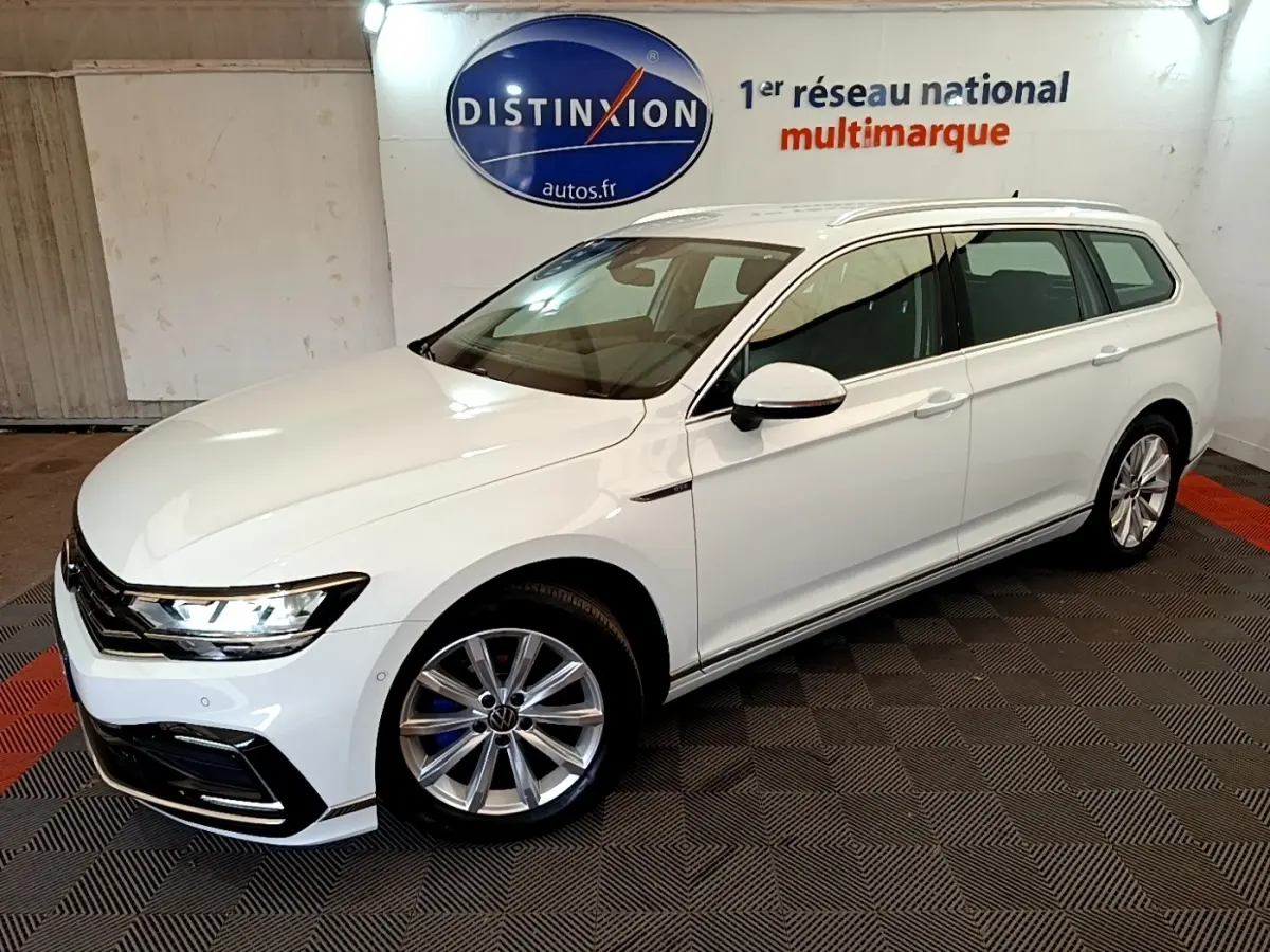Volkswagen Passat 1.4 TSI hybride blanche vue 3/4 avant droit en intérieur showroom avec jantes alliage.