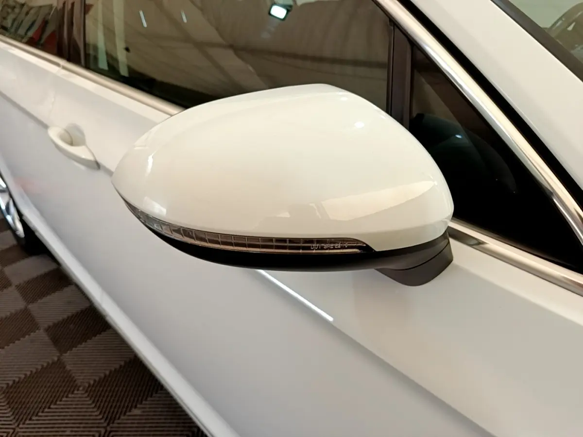 Rétroviseur droit blanc de Volkswagen Passat hybride 2021, vue rapprochée sur la portière et la vitre teintée.