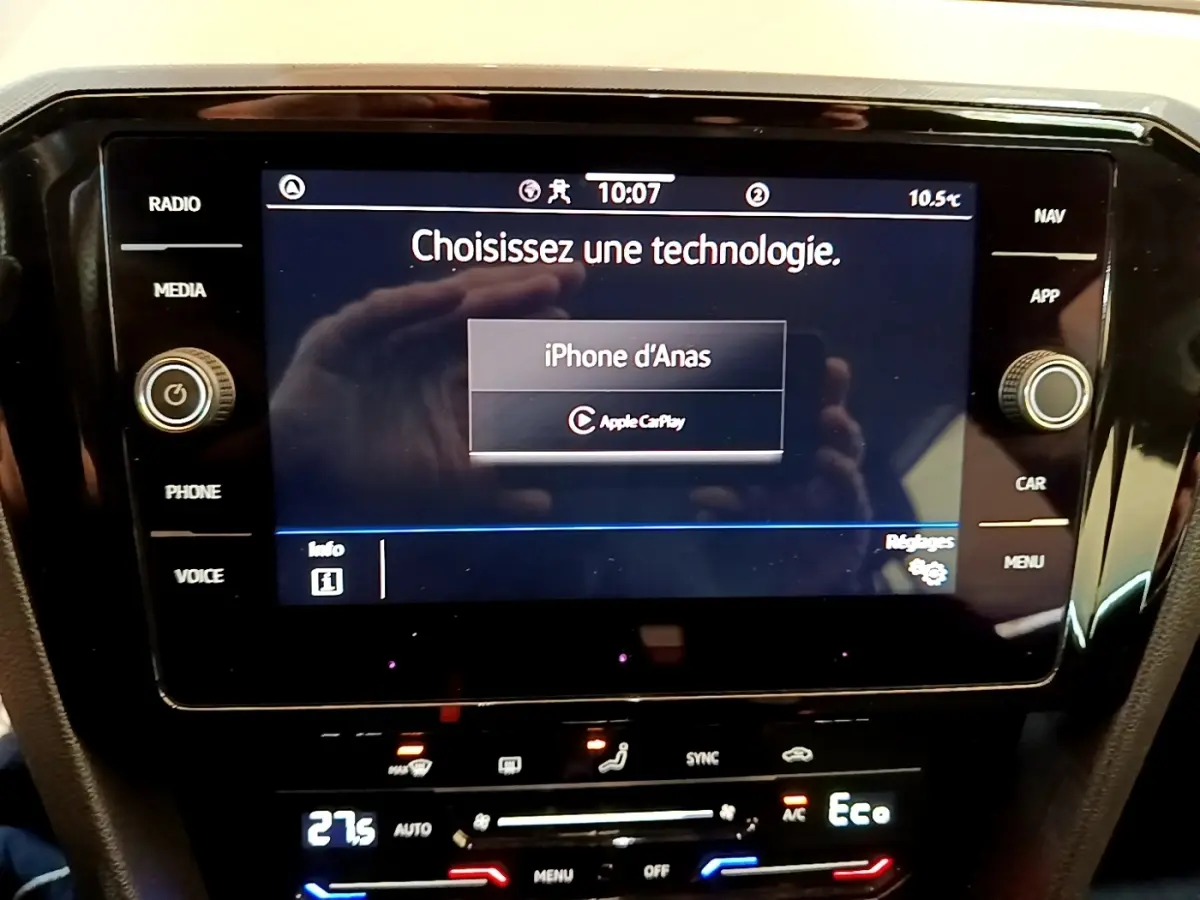 Écran tactile central de la Volkswagen Passat hybride blanche, affichant la connexion Apple CarPlay.
