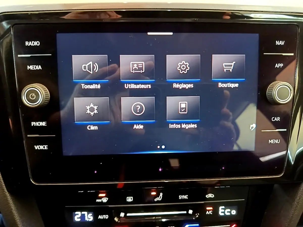 Écran tactile central affichant le menu principal de la Volkswagen Passat hybride blanche, vue de face intérieure.