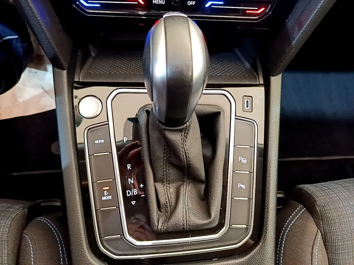 Le levier de vitesse automatique noir de la Volkswagen Passat hybride rechargeable vu de dessus, entouré de boutons de commande.