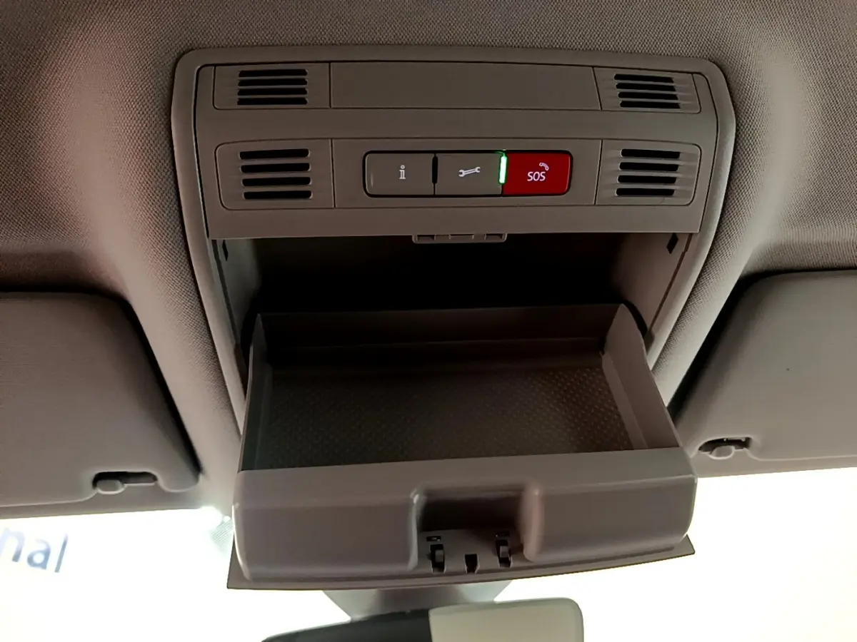 Vue intérieure en plongée du compartiment de rangement ouvert au plafond d'une Volkswagen Passat blanche hybride rechargeable.
