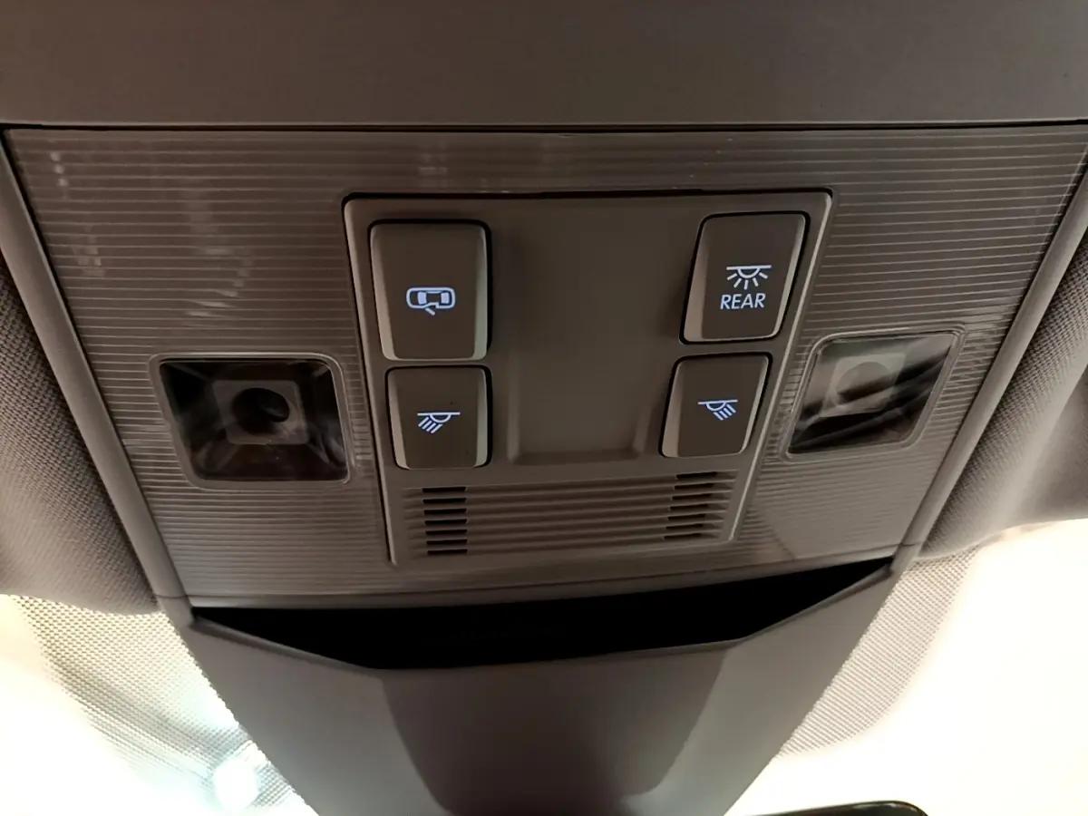 Vue en gros plan du plafonnier gris avec commandes d'éclairage et capteurs dans une Volkswagen Passat blanche hybride 2021.