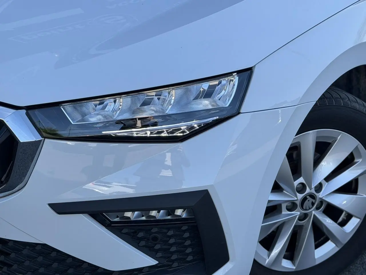Gros plan sur l'avant droit blanc glacier de la Skoda Scala TSI 116 avec phares Full LED et jante alliage 16 pouces.