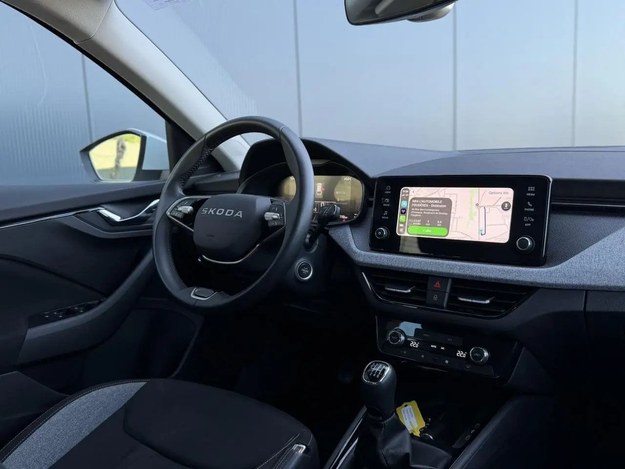 Intérieur de la Skoda Scala TSI 116 blanc Glacier, vue côté conducteur avec tableau de bord et écran tactile.