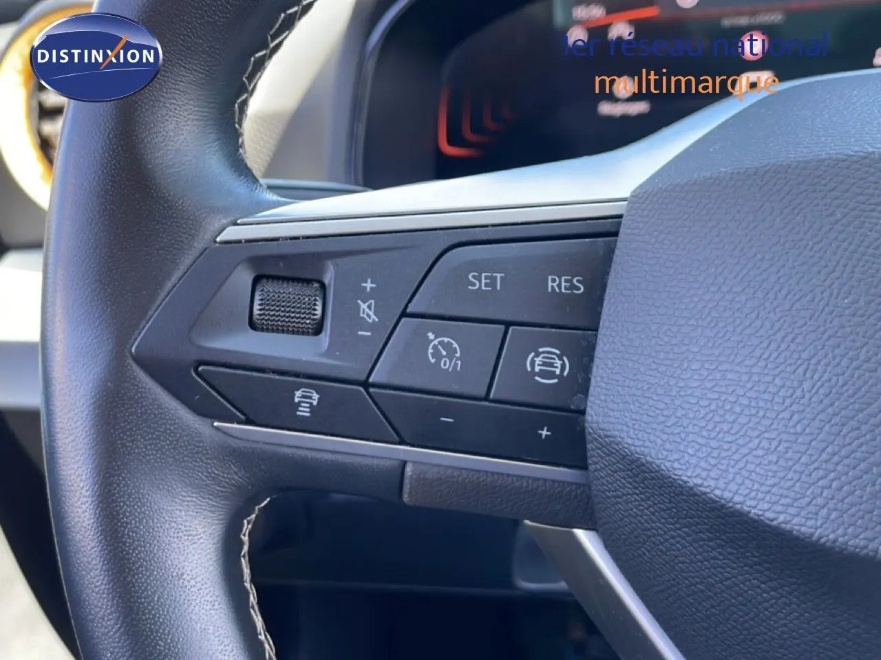 Gros plan sur le volant en cuir noir du SEAT Arona 2025, montrant les commandes de régulateur de vitesse et d'assistance.