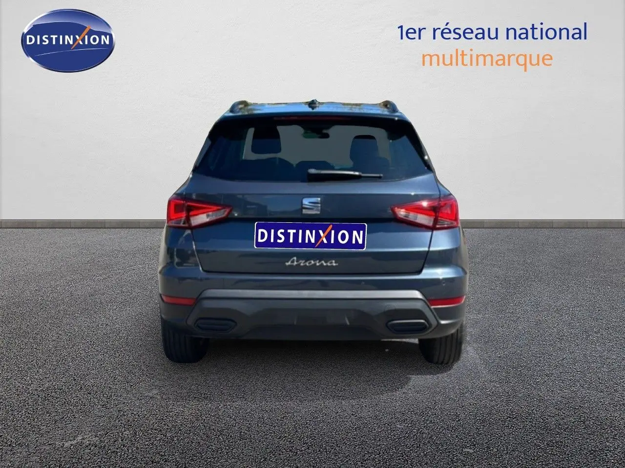 Vue arrière d’un SEAT Arona gris Magnetic Metal avec toit noir, affichant ses feux arrière et le logo distinctif.