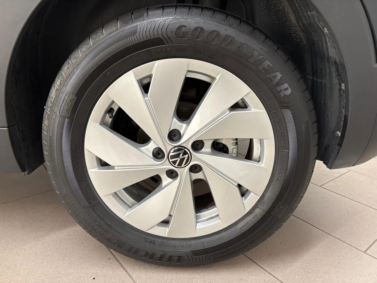 Gros plan sur la roue avant gauche du Volkswagen T-Cross noir intense avec jante alliage et pneu Goodyear.