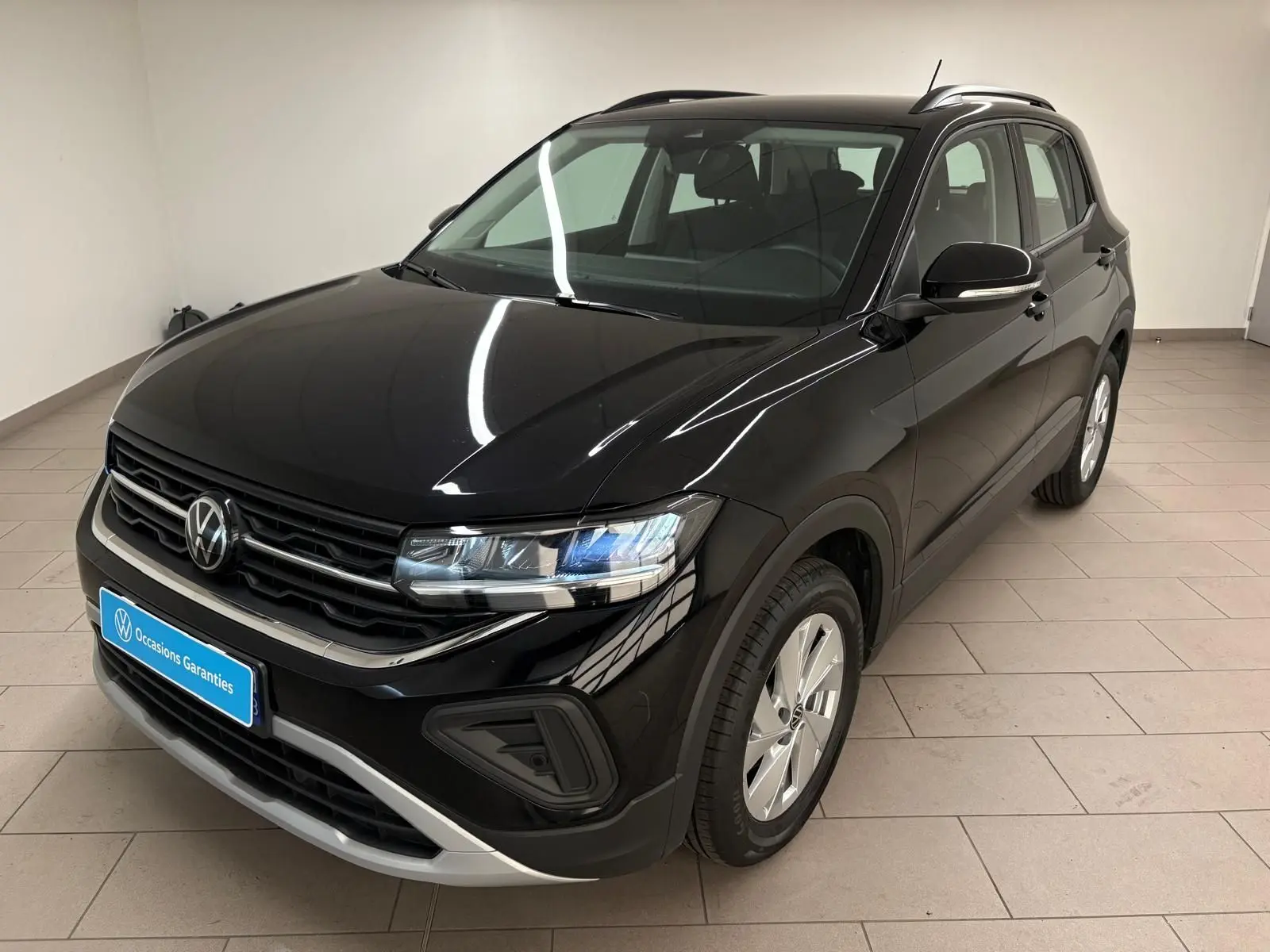 Volkswagen T-Cross noir intense vu en 3/4 avant droit, avec calandre chromée et jantes argentées.