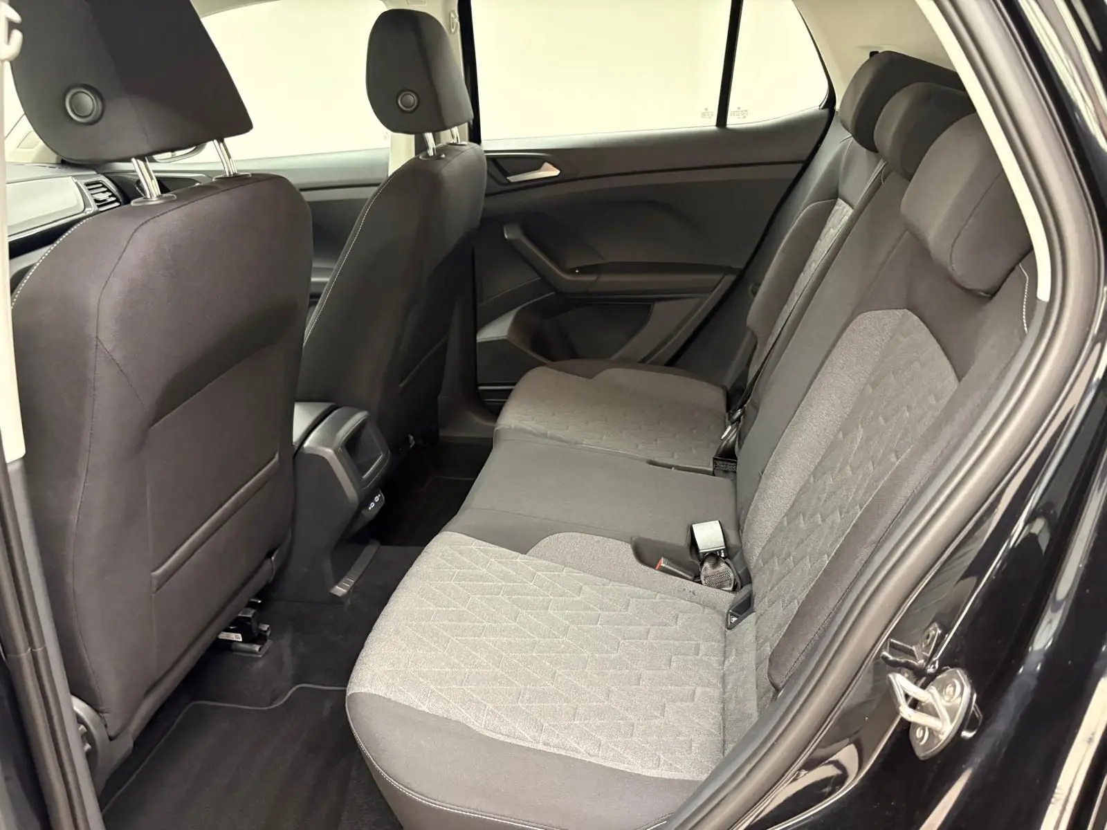 Vue intérieure côté droit des sièges arrière gris et noirs du Volkswagen T-Cross 2024 noir intense.