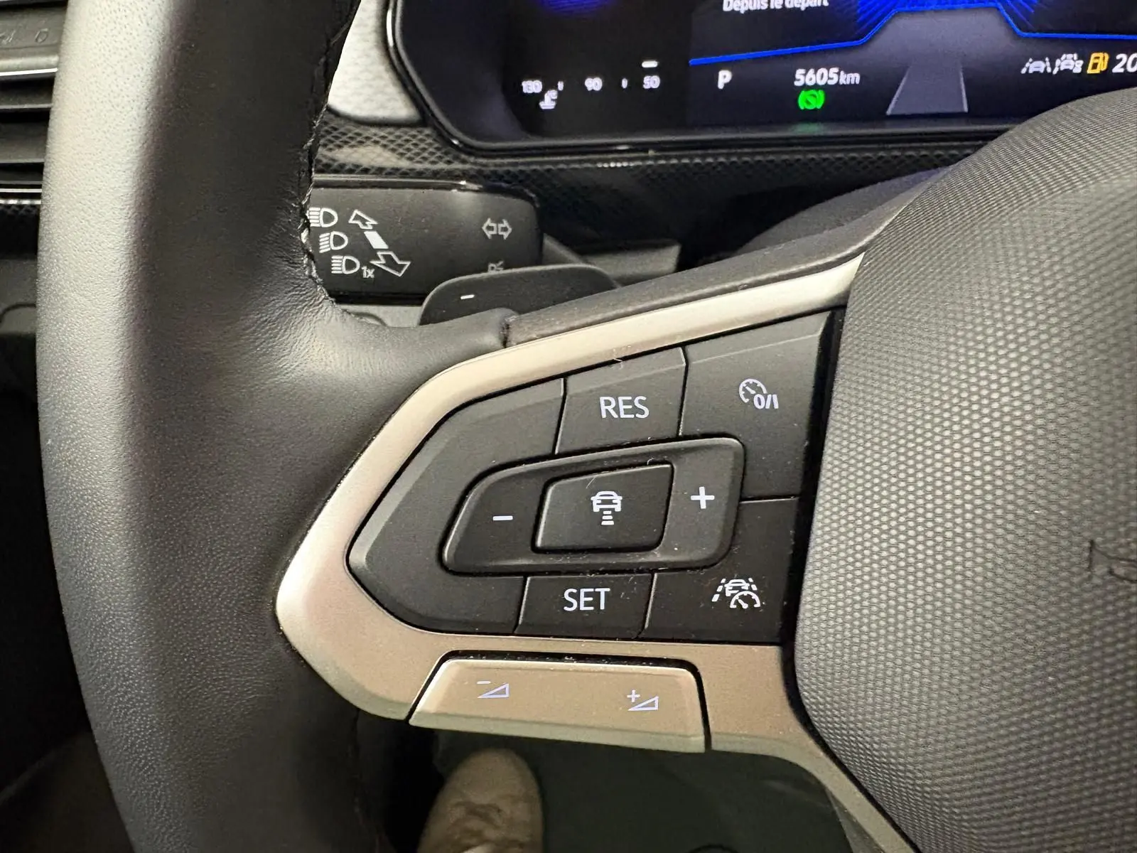 Gros plan sur les commandes de régulateur de vitesse au volant du Volkswagen T-Cross noir intense 2024.