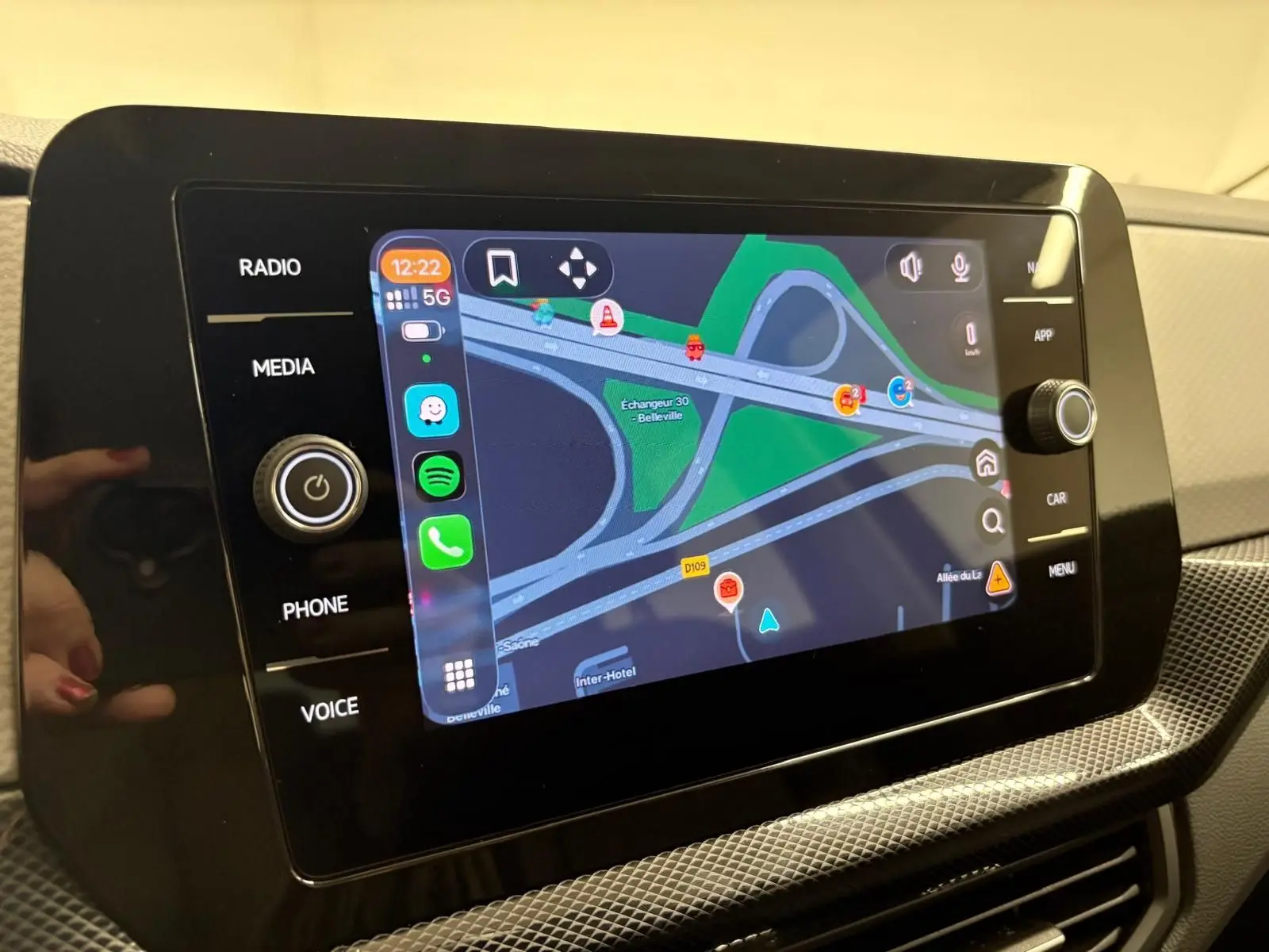 Écran tactile central du Volkswagen T-Cross 2024 affichant la navigation avec interface connectée et commandes autour.